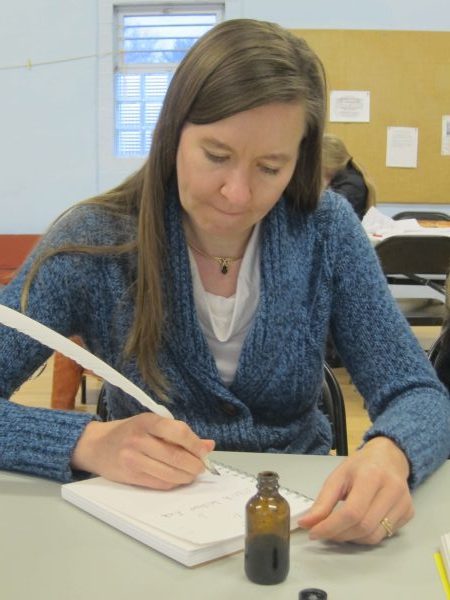 Woman writing with a quill pen.