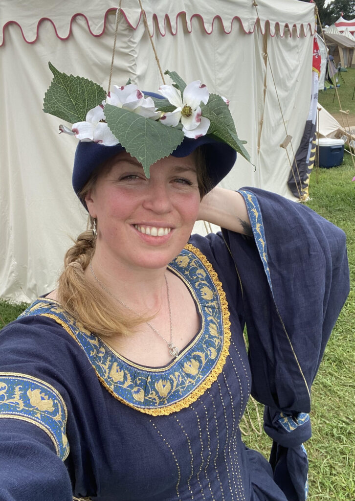 woman in blue dress with bycocket bedecked with flowers and leaves